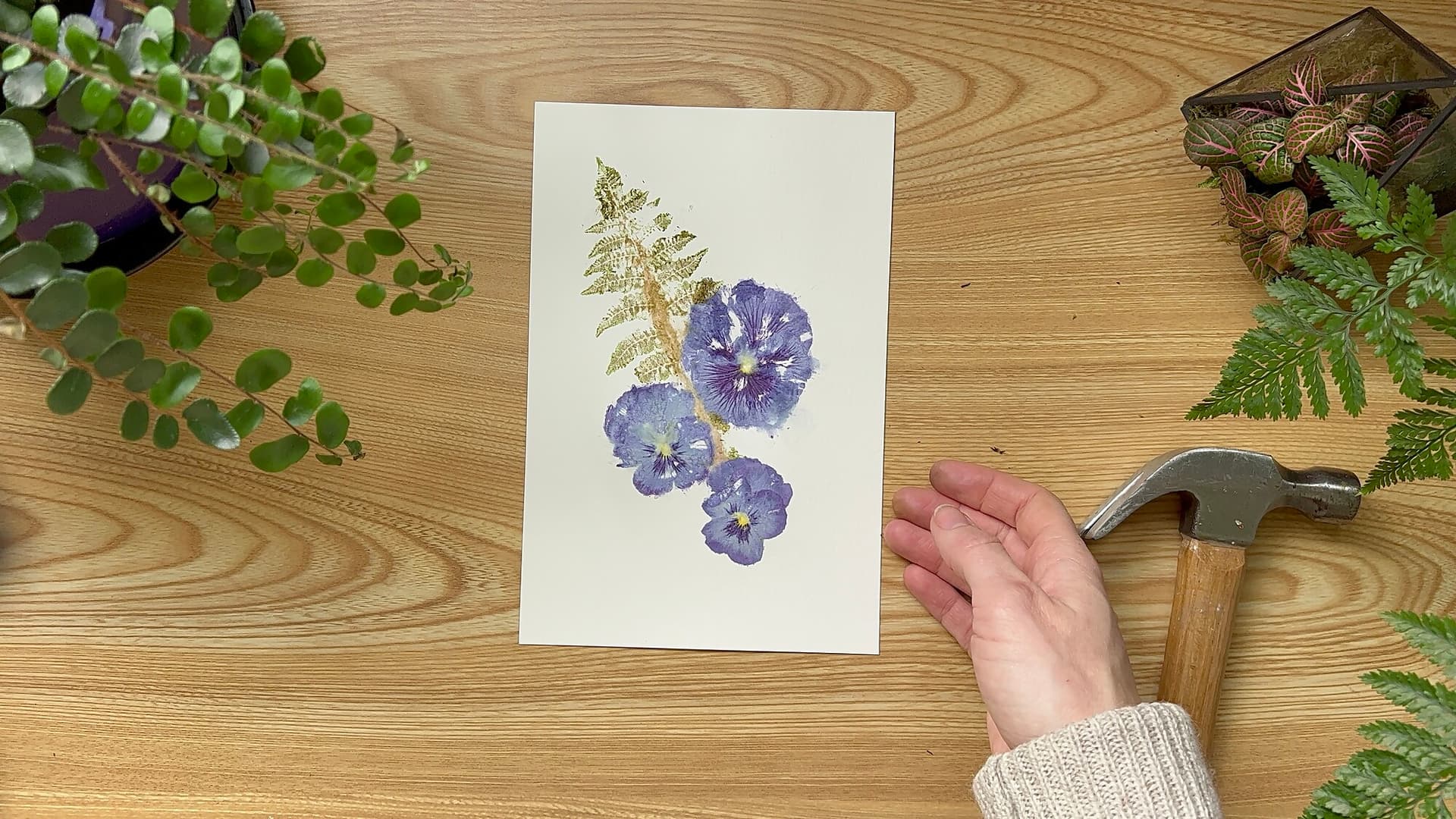 Table with hammered flower art and a hammer